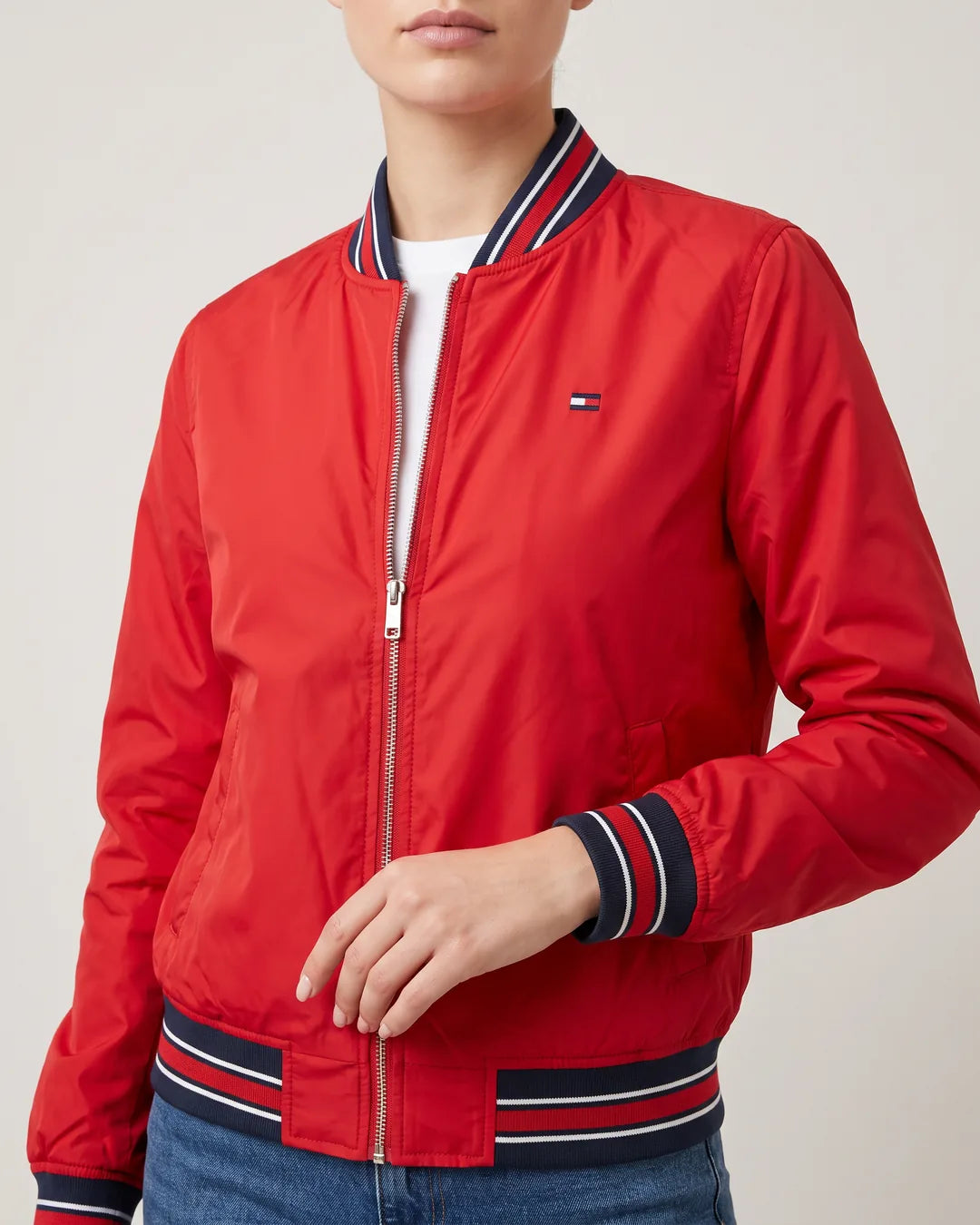 Detalle de cuello, puños de rayas y logo bordado de la chaqueta bomber Tommy Varsity